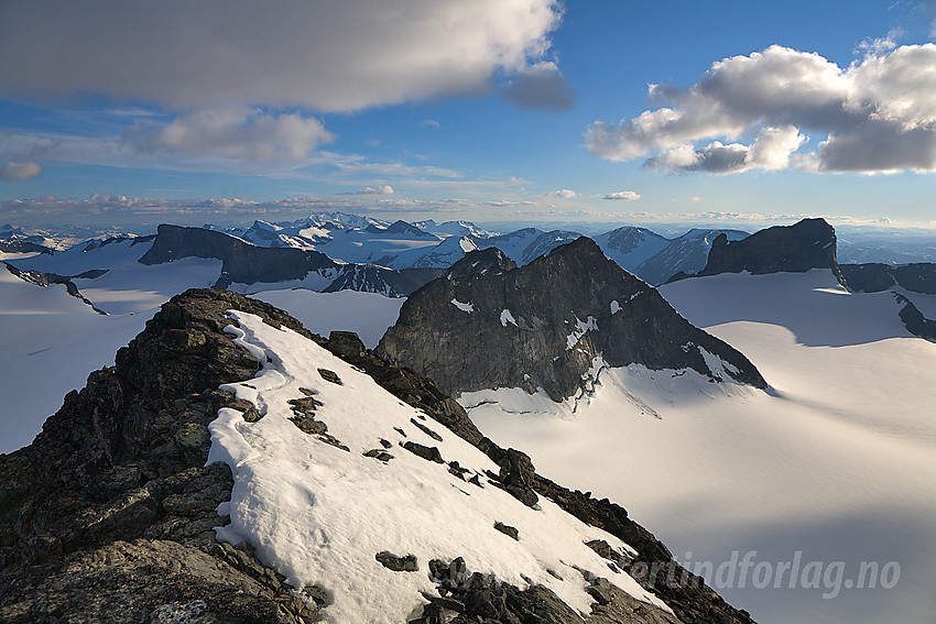 Nesten på toppen av Galdhøpiggen med utsikt mot bl.a. Storjuvtinden (2344 moh) i midten, Skardstinden (2344 moh) til høyre og Bukkehøe (2314 moh) mer mot venstre.