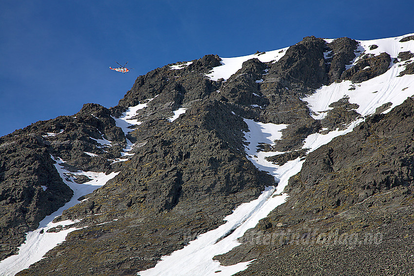 Sea King redningshelikopter sirkler over fjellene rundt Glittertinden på søk etter savnet person. Her flyr det over Ryggjehømassivet. Denne gangen gikk det veldig bra.