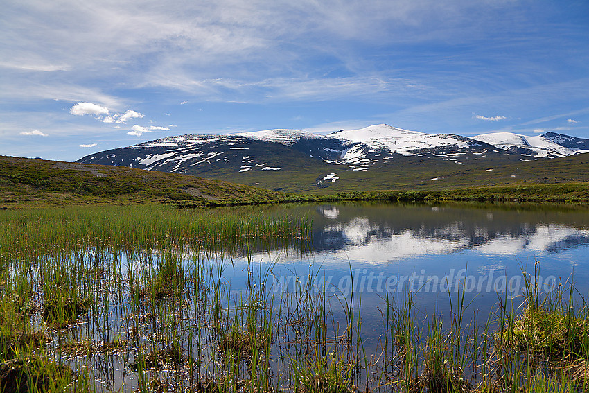 I Veodalen med et lite tjern som speiler Aust-Stornubben, Stornubben og Nautgardstinden, for å nevne noen.