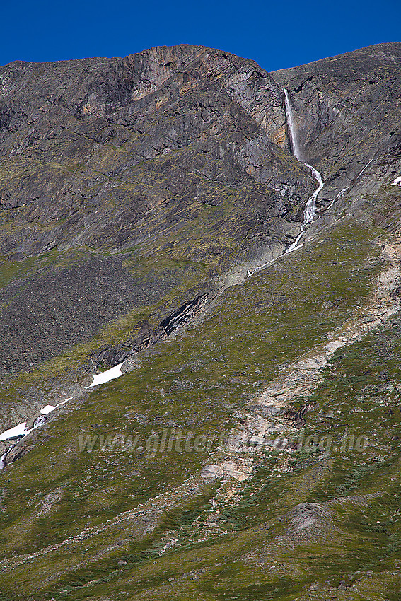 Høyt oppe i fjellsiden over Spiterstulen i Visdalen kaster den flotte Spiterfossen seg utfor en loddrett fjellside.