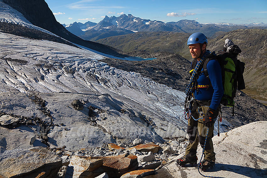 Pause på svaberget i kant av Stølsnosbreen. I bakgrunnen ruver Hurrungane.