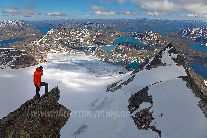 På et luftig fremspring ved Uranostinden. Sørryggen og Uranosbreen i bakgrunnen. I det fjerne ses bl.a. Bygdin og Tyin.