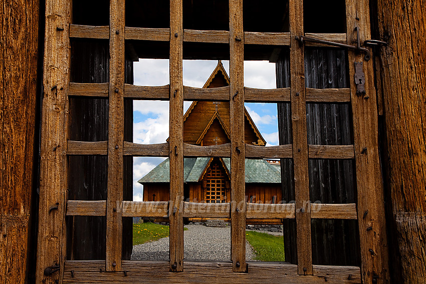 Porten på Reinli stavkirke med inngangspartiet i bakgrunnen.