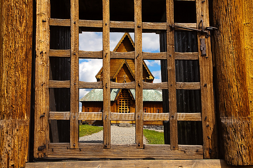 Porten på Reinli stavkirke med inngangspartiet i bakgrunnen.