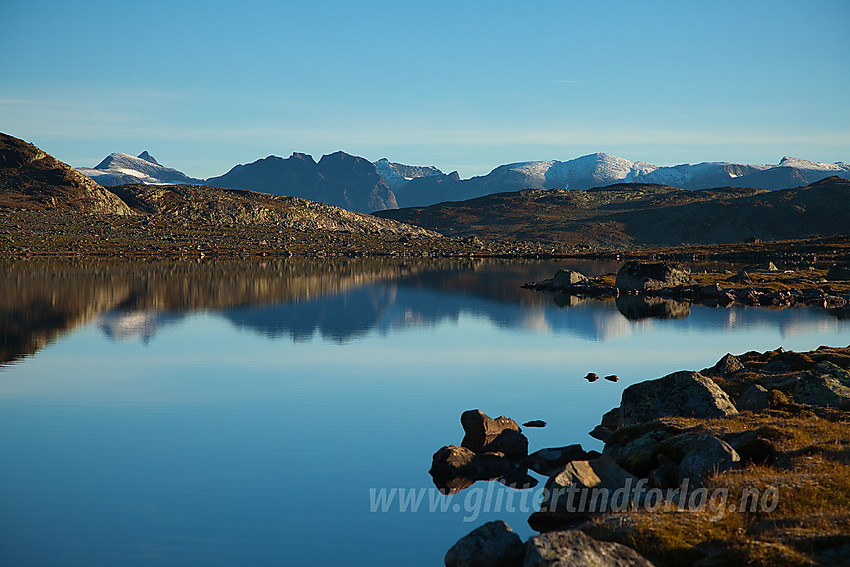 Morgenstund ved Langetjernet nedenfor Tomashelleren med Gjendealpene i Jotunheimen som speiler seg i vannet.