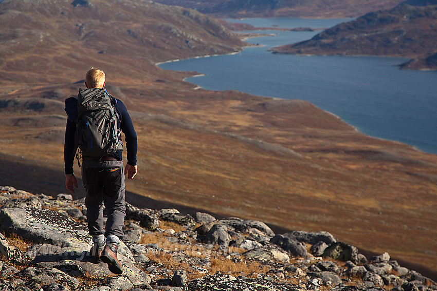 Fjellvandrer på vei ned fra Nørdre Kalvehølotinden mot Bygdin som ses i bakgrunnen.