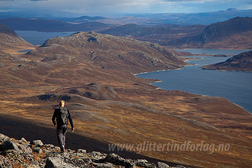 Fjellvandrer på vei ned fra Nørdre Kalvehølotinden mot Bygdin som ses i bakgrunnen.