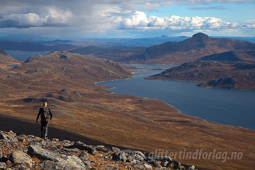 Fjellvandrer på vei ned fra Nørdre Kalvehølotinden mot Bygdin som ses i bakgrunnen.