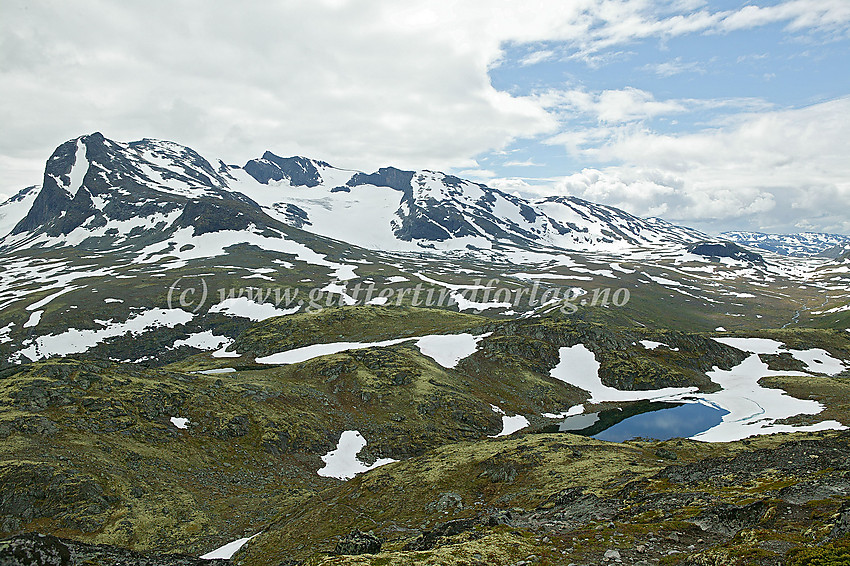 Utsikt i sørlig retning fra Gjendetunga mot Slettmarkhøe (2190 moh.) til venstre, Slettmarkpiggen (2164 moh.), i midten, og Slettmarkkampen (2032 moh.), fortsatt i midten men noe lenger mot høyre. Sentralt i bildet ses Slettmarkbrean, for anledningen nesten fullstendig dekket av snø.