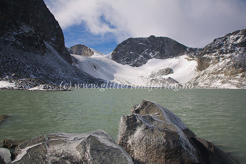 Ved Trollsteintjønne i Trollsteinkvelven mot Grotbrean. Sentralt i bildet Trollstein-Rundhøe (2170 moh.) med Dronningje (2189 moh.) i bakgrunnen. Fjellveggen som forsvinner ut av bildet til venstre tilhører Grotbreahesten (2018 moh.)