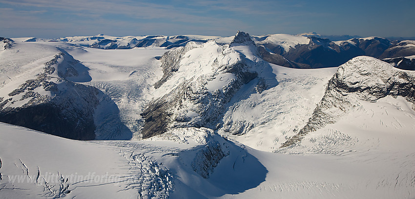 Til venstre ser man nesten Brenibba. Sentralt i bildet ses Småttene (tv.) og Lodalskåpa (2083 moh th.) Lenger til høyre ses Strupebreen etterfulgt av Tverrfjellet (1888 moh).