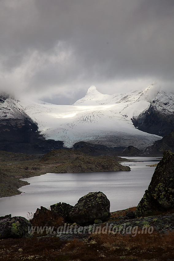 Utsikt innover Store Mjølkedalsvatnet mot Mjølkedalsbreen. En kritthvit Sagi troner mot skydekket i bakgrunnen.