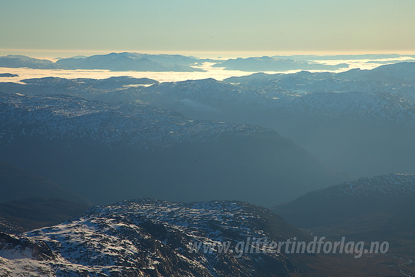 Utsikt fra Store Austanbotntinden i retning Valdres. Over Tyin ligger et kompakt tåkelokk.