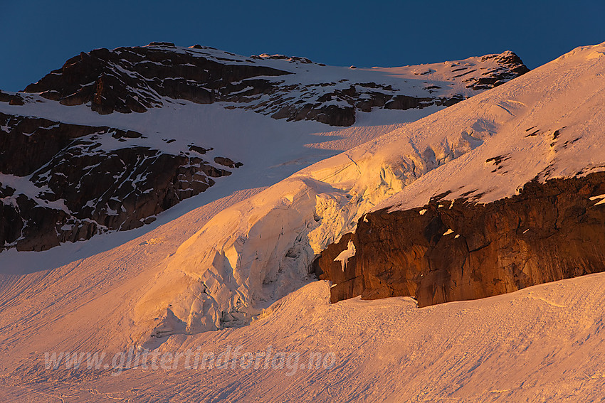 Isdetaljer på Gjertvassbreen i morgensol. Gjertvasstinden (2351 moh) ruver i bakgrunnen.