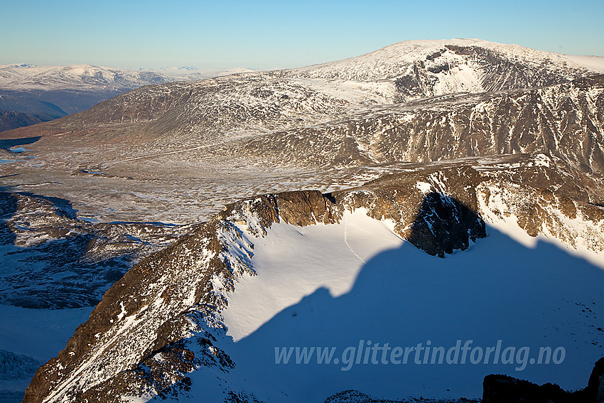 Utsikt fra Store Veotinden mot de nordlige Veotindene og Glittertinden. Legg merke til sporene våre ned på snøfeltet.