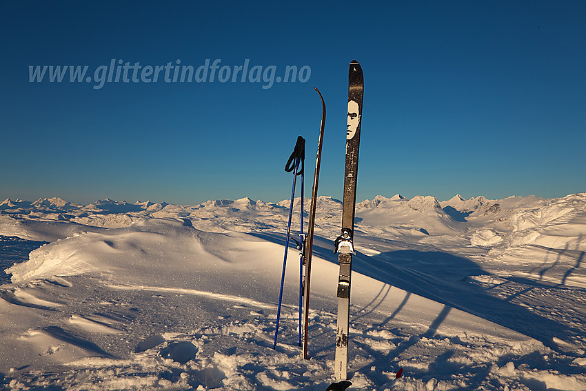 Ski på toppen av Mugnetinden. Jotunheimen i bakgrunnen.