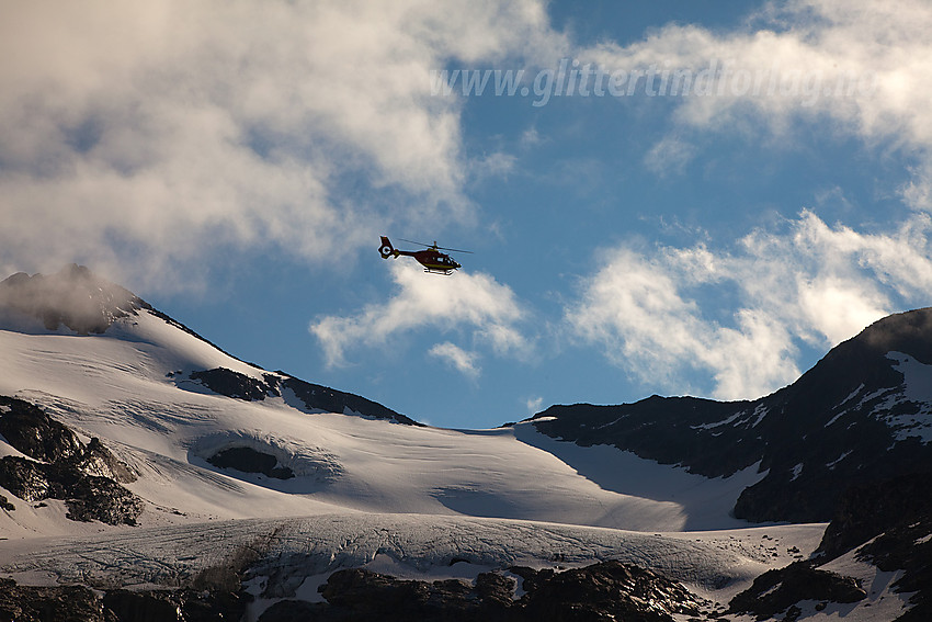 Fra Svartdalen mot Svartdalsbrean og Langedalstinden (2206 moh.). Over flyr et helikopter på redningsoppdrag.