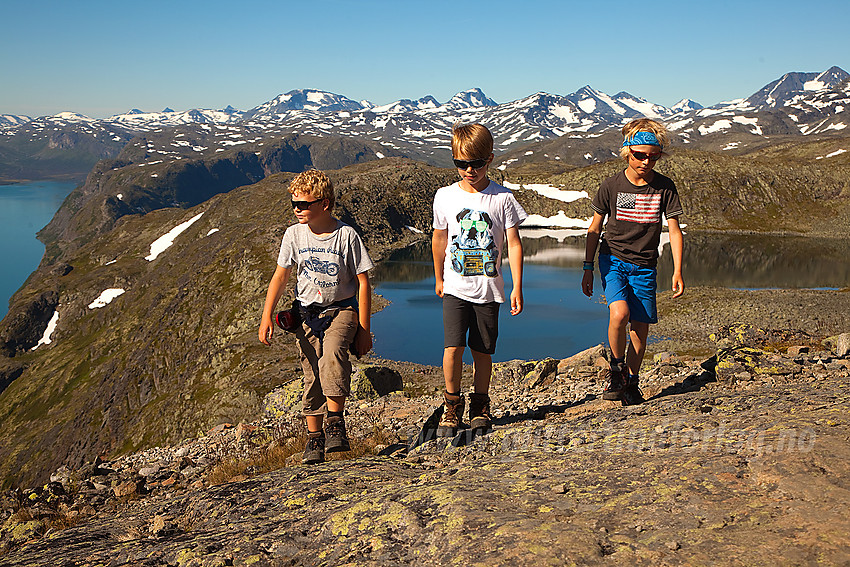 Spreke barn på fellestur med Barnas Turlag Valdres over Besseggen i fint driv på vei opp fra Bjørnbøltjønne. Sentraljotunheimens tinder i bakgrunnen.