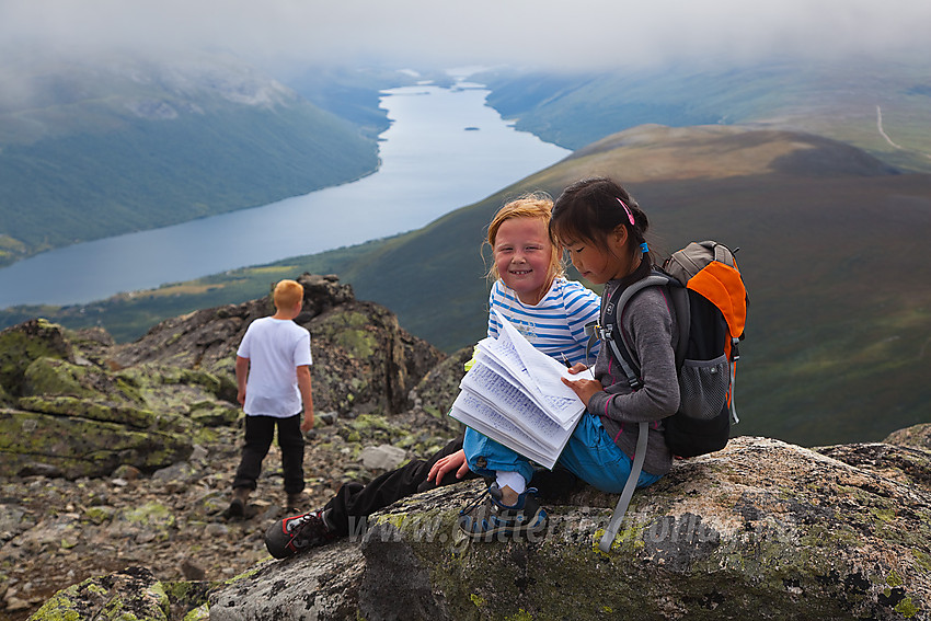 Innskriving i toppboka på toppen av Grindane. Helin i bakgrunnen.