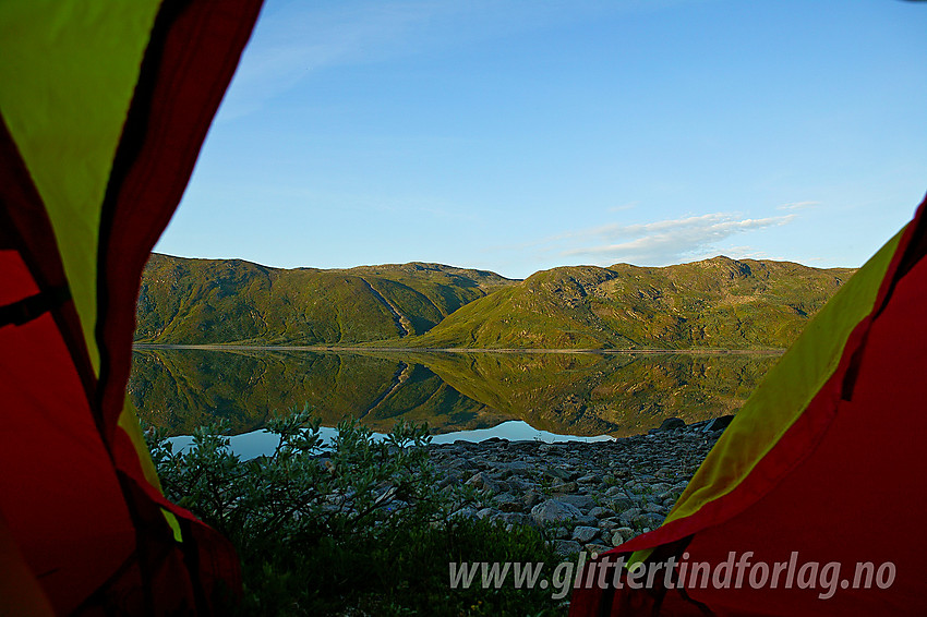 Morgenstemning ut gjennom teltåpningen på Bygdins nordbredd. På andre siden Skjeldrane, en fjellrygg på sørsiden av innsjøen.