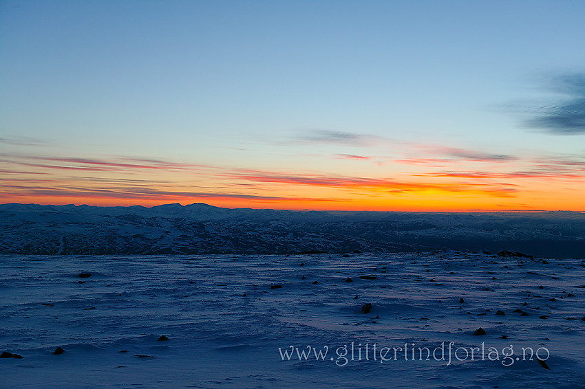 På toppen av Store Kvitingskjølen (2064 moh) en vårmorgen. I det fjerne ses silhuetten til Dovrefjell.