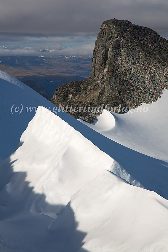 Oppunder toppen på Søre Veotinden (2267 moh), med utsikt bort til Store Veotinden (2240 moh). I forgrunnen fint lysspill på snøformasjoner i forbindelse med bregleppe på overgangen mot Styggehøbrean.