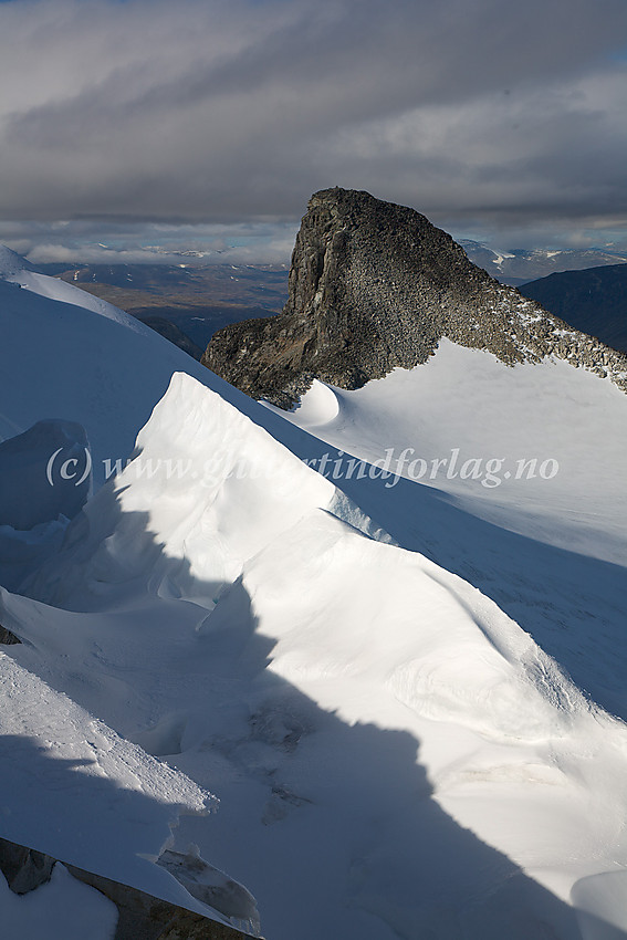 Oppunder toppen på Søre Veotinden (2267 moh), med utsikt bort til Store Veotinden (2240 moh). I forgrunnen fint lysspill på snøformasjoner i forbindelse med smeltekløft på overgangen mot Styggehøbrean.