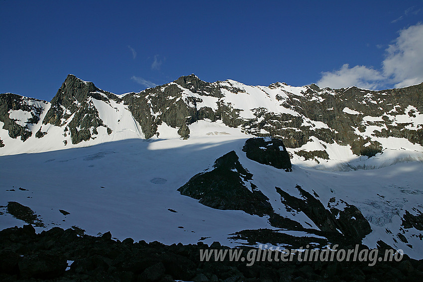 Ved fronten på Skagastølsbreen en sommermorgen med Dyrhaugstindane i bakgrunnen. Fra venstre mot høyre: Søre (2072 moh), Midtre Sør (2134 moh), Midtre Nord (2135 moh) og Store (2147 moh).