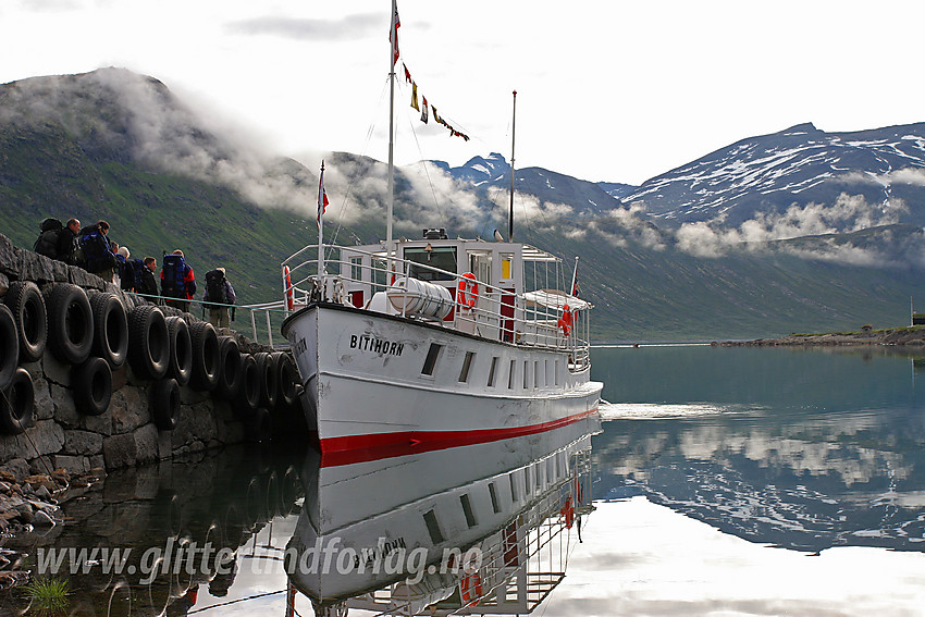 Passasjerer går ombord i m/b Bitihorn ved Eidsbugarden. I bakgrunnen til høyre ses Galdebergtinden (2075 moh).