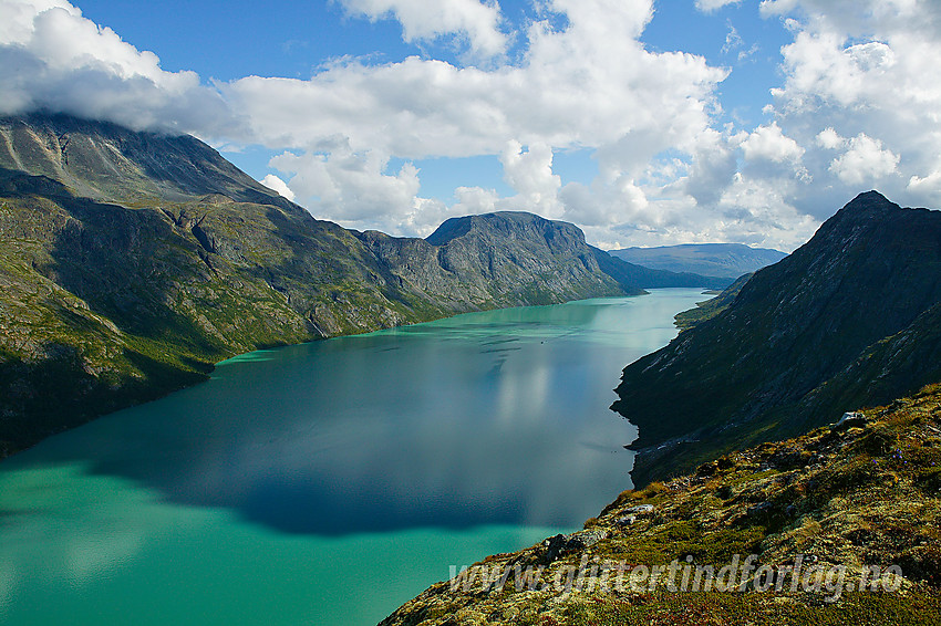 Utsikt i nordøstlig retning fra Memuruhåmåren mot Besshøe, Besseggen og Veslfjellet. Ute på Gjende ser man Gjendebåten på vei vestover som en liten prikk.