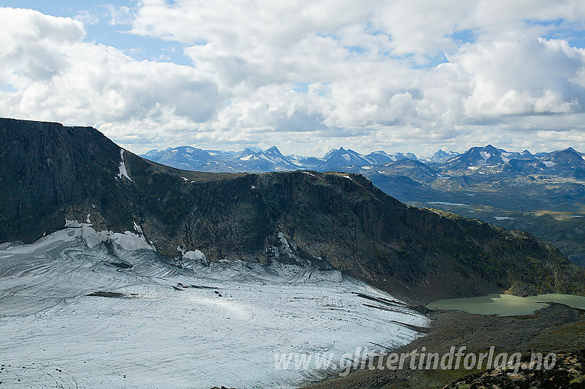 Fra Eggen mot Nørdre Tjønnholet, breen, brevannet og ryggen på andre siden. I det fjerne ses en rekke av tindene i sentrale deler av Jotunheimen.