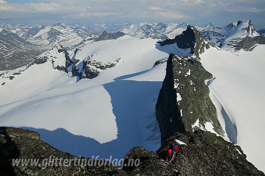 På vei opp siste biten til Store Smørstabbtinden fra sør. I bakgrunnen ryggen via Kniven (2133 moh) og Sauen (2077 moh) ut til Sokse (2189 moh). Bak til høyre ses Storebjørn. Til høyre ligger Leirbrean, mens den kvasse Knivseggen kaster lange skygger utover Storbrean til venstre.