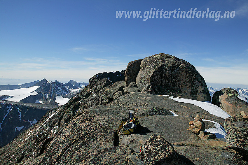 Ved Steinflytinden (2318 moh). Selve toppen ligger omtrent som ei "vorte" oppe på ryggen og krever 2-3 meter klyving for å bestiges. Når det ligger litt snø, er det enkelt midt i mot, men på snøfritt føre som her, er det kanskje enklest opp den tydelige sprekken på venstre side av toppblokka.