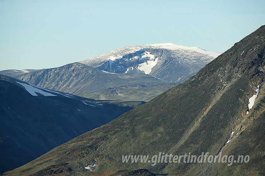 Med telelinse fra Bukkehåmåren mot Glittertinden (2464 moh). Til venstre foran Glittertinden ses Ryggjehøe (2142 moh). Til høyre i forgrunnen ses deler av Besshøe (2258 moh).