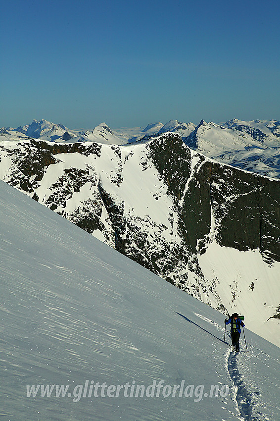 På vei opp den bratt snøfonna nordøst for Steinflytinden med Tjønnholstinden NV2 (2208 moh) i bakgrunnen.