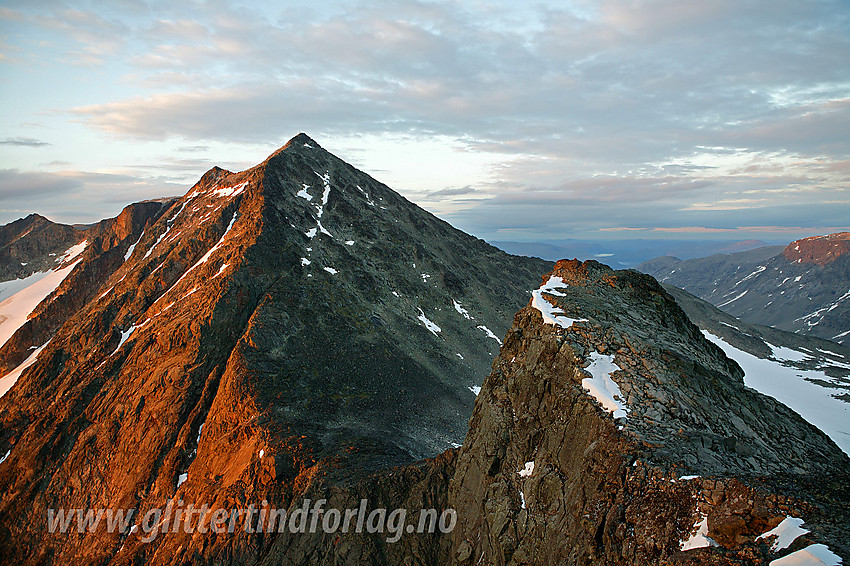 På ryggen øst for Vestre Leirungstinden med Midtre Leirungstinden (ca. 2130 moh) i forgrunnen og Austre Leirungstinden (2280 moh) i bakgrunnen. En ikke uvanlig rute ned vestsiden på Austre Leirungstinden følger omtrent samme linje som snøfeltene på skrå til høyre for ryggen, og fortsetter i omtrent samme retning videre ned i skaret mot Vestre Leirungstinden.