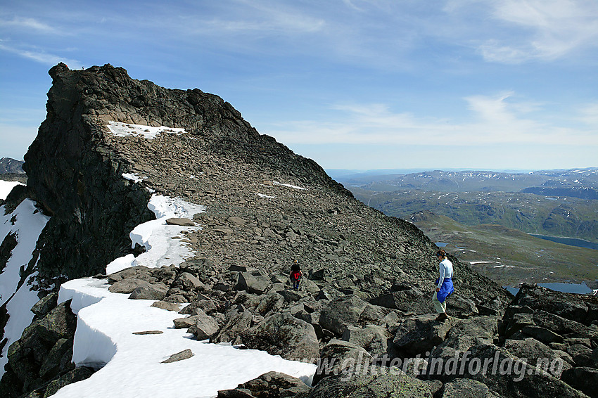 Like vest for Slettmarkpiggen (2164 moh). Toppen er den luftige "vorta" helt ut til venstre mot stupet. Man ser også små menneskekryp oppe ved toppen.
