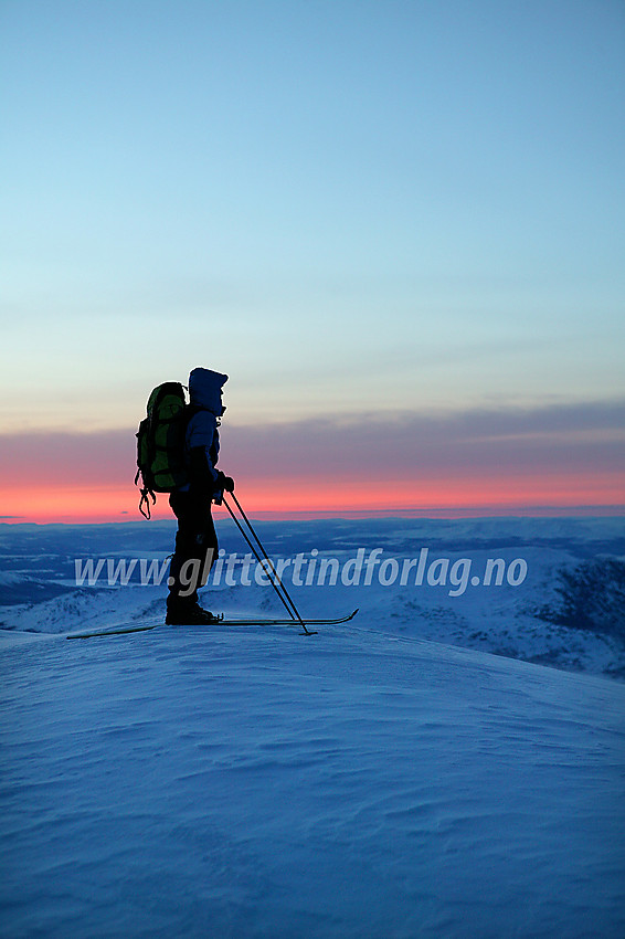 Skiløper på toppen av Besshøe en aprilmorgen. Det blåser og det er kaldt, men for øvrig er det en helt herlig stemning.