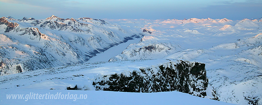 Utsikt i sørvestlig retning fra Besshøe en flott vintermorgen. Til venstre i bildet Gjendealpene med Store Knutsholstinden (2341 moh) som høyeste topp. Langt nede ses langstrakte Gjende godt dekket av is.