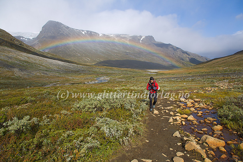 Fjellvandring i Visdalen på merket sti sørover fra Spiterstulen. I bakgrunnen til venstre, over regnbuen, ses den såkalte "1914-toppen" og en flik av Svellnosbrean.