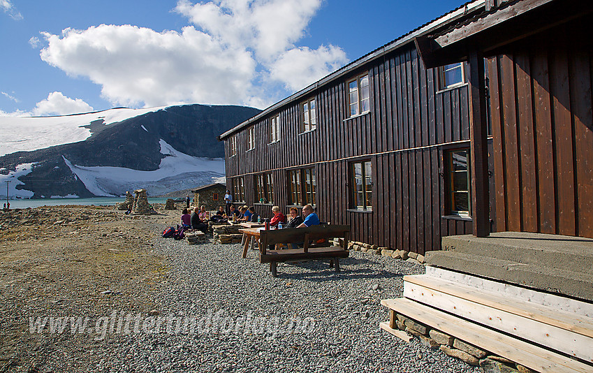 Fornøyde fjellturister nyter været og utsikten ved solveggen på Juvasshytta.