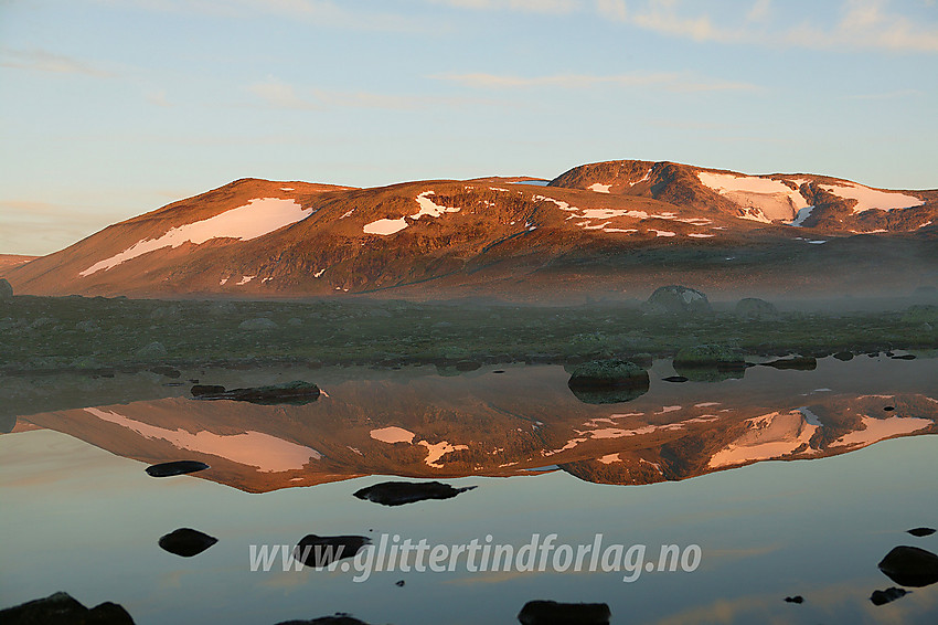 En tidlig sommermorgen på Valdresflye. Rasletinden (2105 moh.) speiler seg i Fisketjedne.