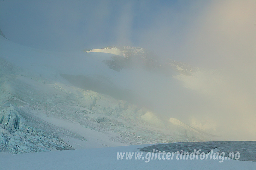 Trolsk stemning på Gjertvassbreen. Gjennom tåka kan man skimte det imponerende brefallet, Gjertvasskardet og Styggedalstinden (2387 moh).