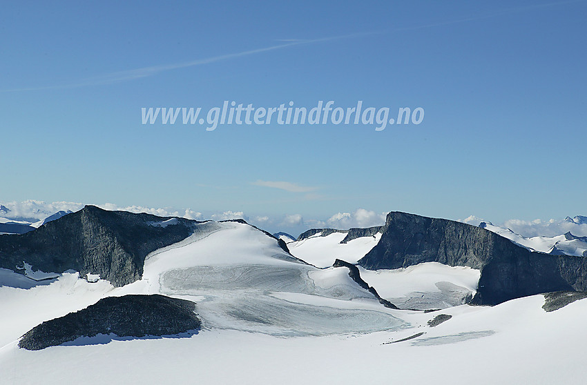 Fra den siste bakken opp til Galdhøpiggen med utsikt over Svellnosbrean mot Store Tverråtinden (2309 moh.). Til høyre på fjellryggen til denne ligger Vestre (2288 moh.) og Nørdre Tverråtinden (2210 moh.). Helt i forgrunnen til venstre stikker Svellnosbreahesten (2181 moh.) ut av breen, og lenger bak til høyre ses den klassiske profilen til Bukkehøe (2314 moh.) med dens imponerende øststup.