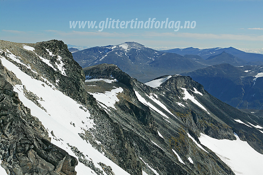 Keilhaus topp (2355 moh.) og Svellnose (2272 moh.) sett fra innunder toppen av Galdhøpiggen. I bakgrunnen reiser Glittertinden (2464 moh.) seg høyt over Skautflye, med Glitter-Rundhøe og Ryggjehøe mot høyre. Helt i bakgrunnen til høyre skimtes Nautgardstindmassivet.