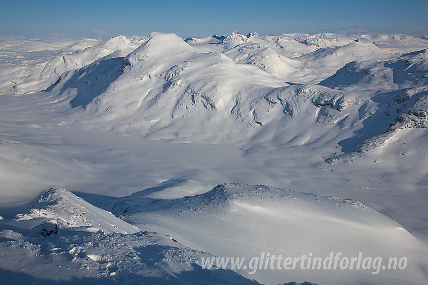 Fra nordvestryggen på Mjølkedalstinden mot Rauddalen og det snødekte Rauddalsvatnet med Store Rauddalstinden (2157 moh) bakenfor.