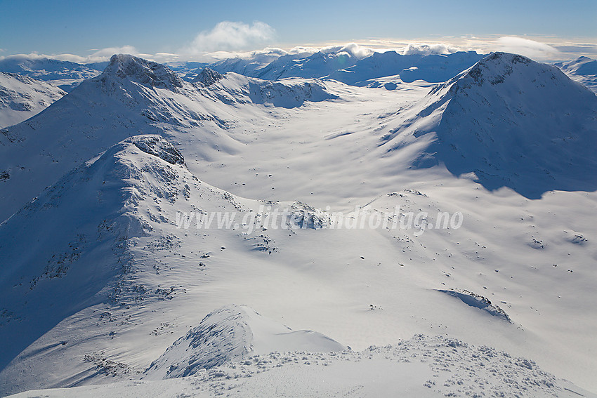 Utsikt fra Mjølkedalstinden mot Olavsbunuten (1970 moh), Rauddalseggje (2168 moh) og Snøholstinden (2141 moh). I det fjerne ses Gjendealpene.